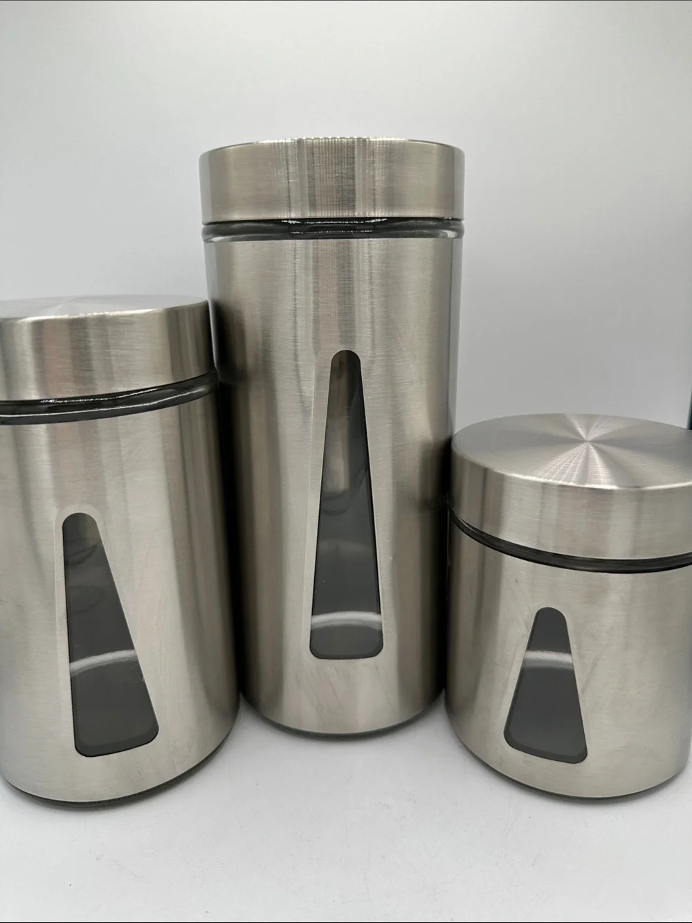 Three-piece steel and glass canister set with triangular viewing windows